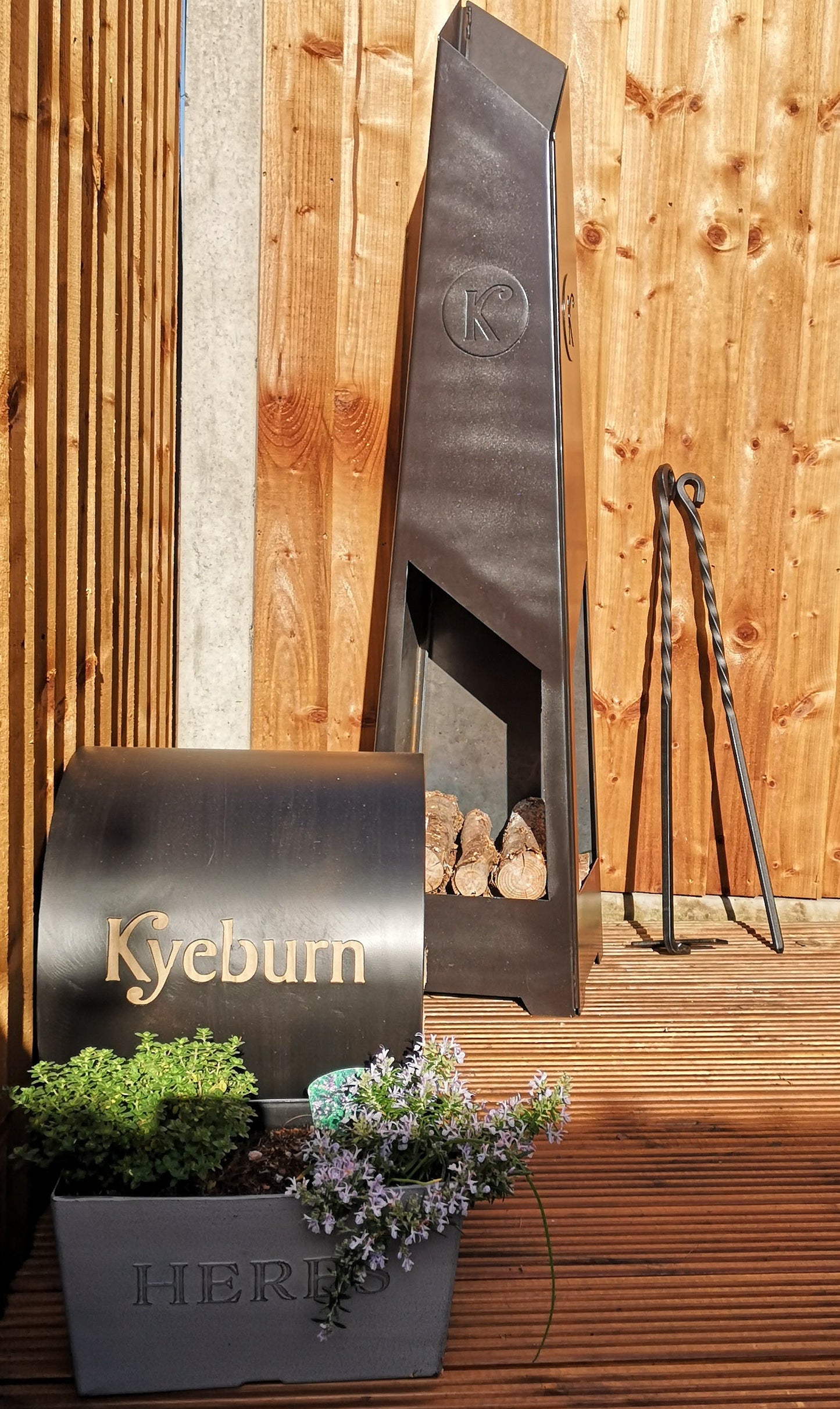 Decorative fireplace tools with 'Kyeburn' branding against a wooden background